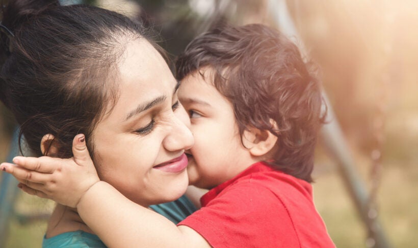 Young child  kissing mother on the cheek