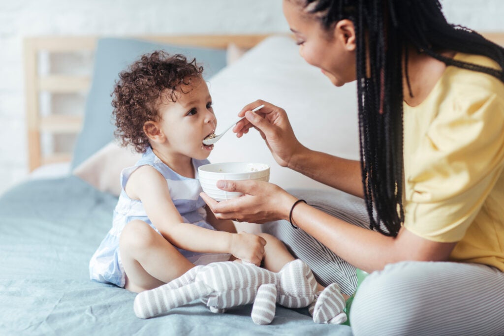 A mother feeding her toddler