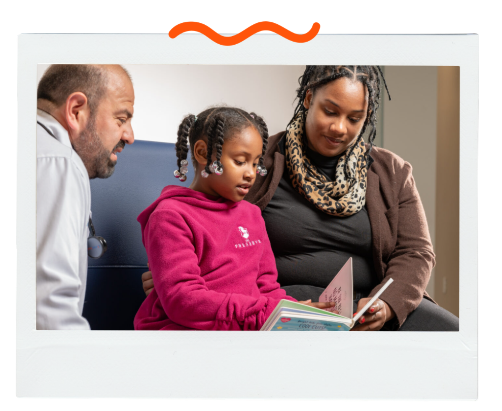 Reach Out and Read provider with a mother and child reading a book